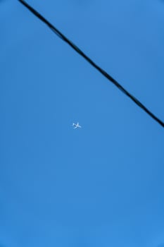 A passenger plane is flying far in the sky. Minimalism photo