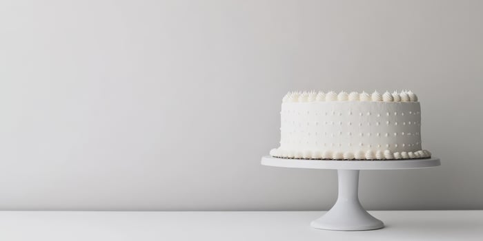 A beautifully designed minimalistic white birthday cake is gracefully displayed on a stylish cake stand, making it the perfect centerpiece for any joyful celebration and special occasion, indeed photo