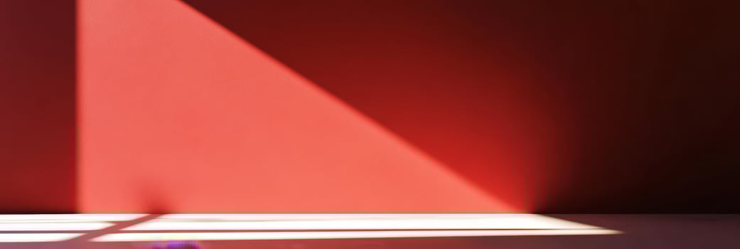 A striking light and shadow interplay contrasts against a vibrant red wall, perfect for modern design themes photo