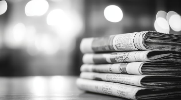 This black and white photograph features a stack of vintage newspapers, evoking nostalgia and showcasing the enduring history of journalism and the culture of reading from a bygone era photo