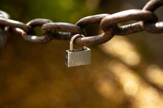 Small padlock on a large vintage chain. A symbol of strong love. Bokeh and blurred back photo