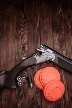 Clay target plates for shooting with rifle on wooden back photo