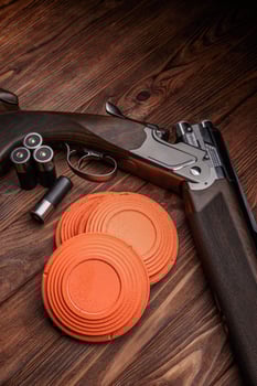 Clay target plates for shooting with rifle on wooden back photo
