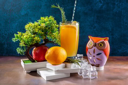 setup of Fresh Orange Juice with Decorative Elements and Natural Scenery photo