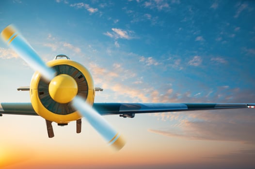 Small aircraft flying above in the blue sky photo