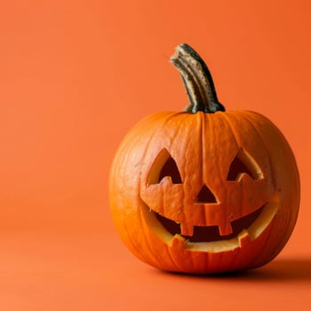 Classic Carved Halloween Pumpkin on Vibrant Orange Background, Holiday Festivity, Autumn Celebration photo