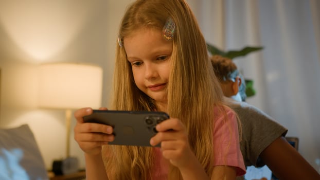 Caucasian boy girl family little children using gadget technologies siblings sister daughter playing smartphone mobile games brother son browsing Internet laptop computer home evening. Devices overuse photo
