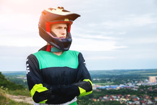 Man, portrait of professional motorcyclist or off-road racer in helmet, confidence for extreme sports. Confident man, expert or racer in outdoor competition photo