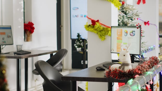 Empty festive ornate office properly decorated for startup Christmas party. Computer monitors at workstations in xmas adorn workplace with no workers during winter holiday season photo