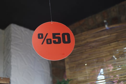 A striking 50 Sale Discount Sign prominently displayed in a retail shopping setting photo
