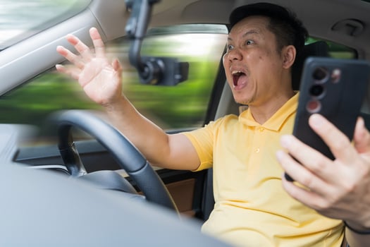 Oh my God, I am going to crash. Careless driver avoiding an accident after using phone in car checking his smartphone photo