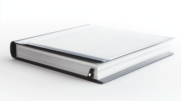 A closed binder resting on a white surface in a well-lit environment photo