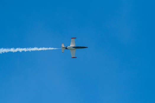 A plane flying in the sky with a white trail photo