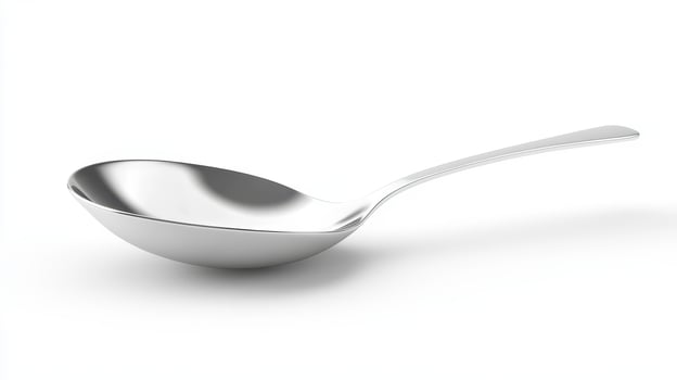 Simple stainless steel spoon on a white background with a smooth surface reflecting light photo