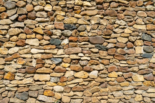 Wall of yellow stone. Abstract natural background. Uneven stone surface. photo