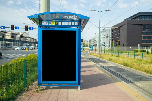 Digital Media blank advertising billboard in the tram bus stop at avenue of Krakow city. Blank billboards public commercial with passengers, signboard for product advertisement design photo