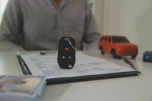 Young man receives a key from car salesman. After agreeing to a contract for rent or sale of a car at workshop, loan car, insurance, sale, buying car and finance concept. photo
