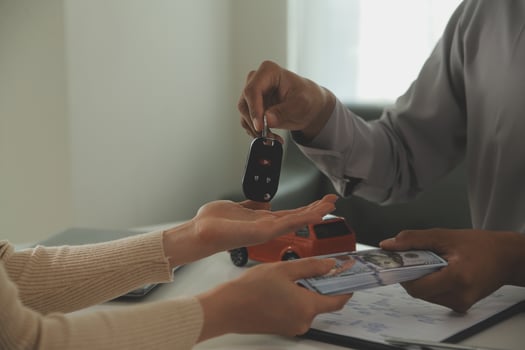 Young man receives a key from car salesman. After agreeing to a contract for rent or sale of a car at workshop, loan car, insurance, sale, buying car and finance concept. photo