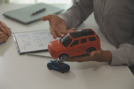 Young man receives a key from car salesman. After agreeing to a contract for rent or sale of a car at workshop, loan car, insurance, sale, buying car and finance concept. photo