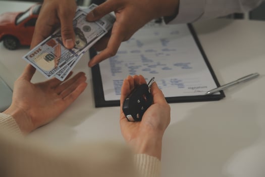 Young man receives a key from car salesman. After agreeing to a contract for rent or sale of a car at workshop, loan car, insurance, sale, buying car and finance concept. photo