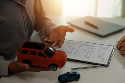 Young man receives a key from car salesman. After agreeing to a contract for rent or sale of a car at workshop, loan car, insurance, sale, buying car and finance concept. photo