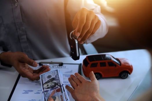 Young man receives a key from car salesman. After agreeing to a contract for rent or sale of a car at workshop, loan car, insurance, sale, buying car and finance concept. photo