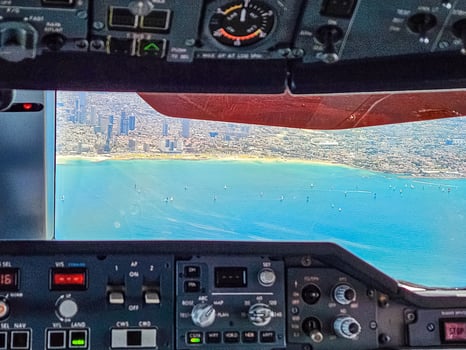 city and sea from airplane cockpit view . High quality photo