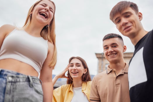 Funny smiling teenagers standing and looking down at camera photo