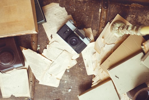 Retro background with vintage camera, case, old books, torn sheets of paper and a candle with melted wax drops. photo