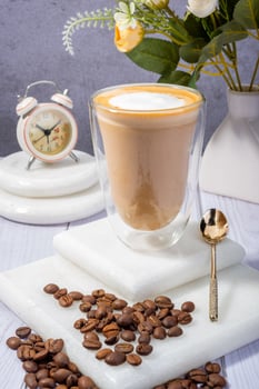 Elegant Latte with Coffee Beans and Vintage Clock on Wooden Table photo