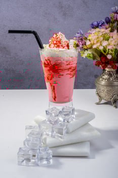 Refreshing Strawberry Smoothie with Ice and Floral Decor photo