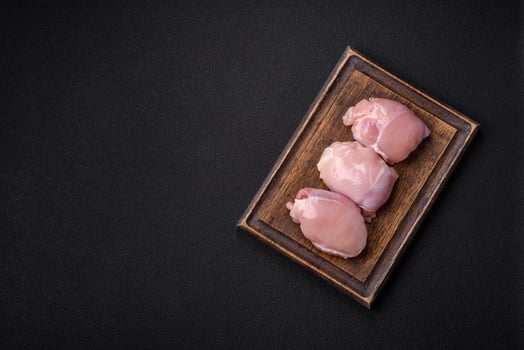 Fresh chicken fillet on a dark concrete table with spices and herbs photo