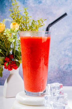 efreshing Strawberry Smoothie with Ice and Floral Decor photo