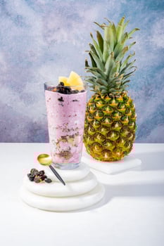 Glass of Pineapple Smoothie with Fresh Fruit and Granola photo
