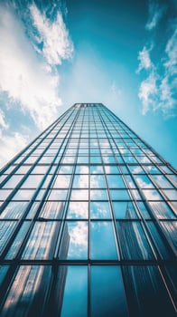 Low angle view of skyscraper with glass windows and blue sky background for business, trade and finance concept photo
