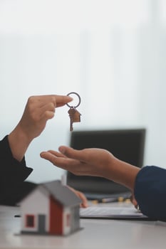 Estate agent giving house keys to client after signing agreement contract real estate with approved mortgage application form, concerning mortgage loan offer for and house insurance. photo