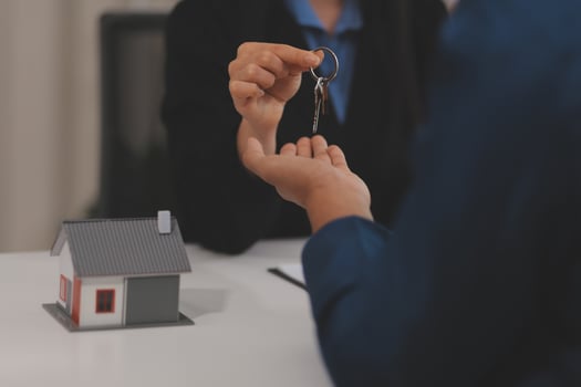 Estate agent giving house keys to client after signing agreement contract real estate with approved mortgage application form, concerning mortgage loan offer for and house insurance. photo