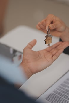 Estate agent giving house keys to client after signing agreement contract real estate with approved mortgage application form, concerning mortgage loan offer for and house insurance. photo