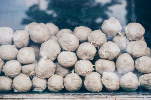 A pile of white meatballs stacked on top of each other. The balls are all the same size and shape. photo