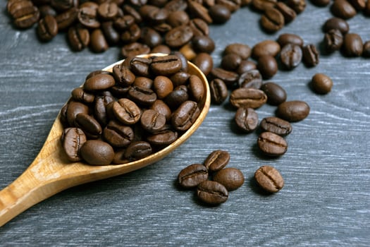 roasted coffee beans with wooden spoon on a wooden background photo