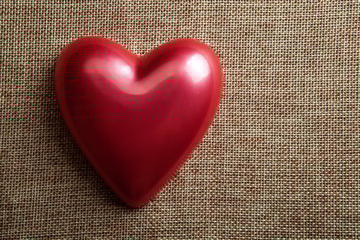red glossy heart on linen top view photo