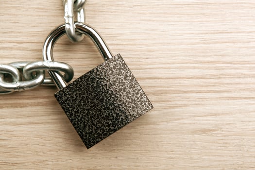 durable padlock with a steel chain on a wooden background security service photo