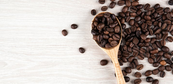 wooden spoon and roasted coffee beans close up photo