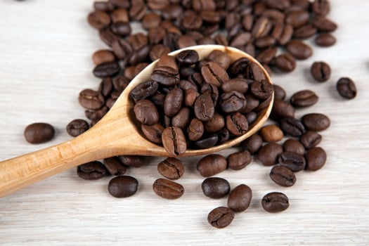 wooden spoon and roasted coffee beans close up photo
