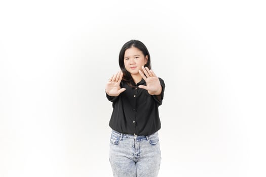Young Asian woman doing stop or rejection sign with palm hand wearing Black t-shirt and jeans isolated on white background photo