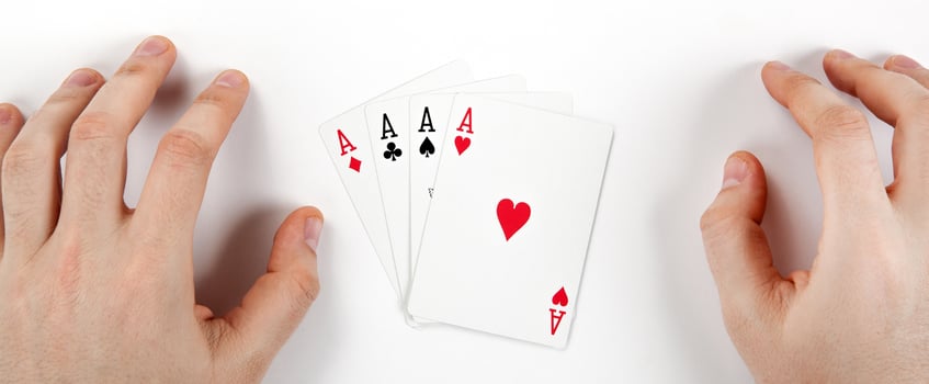 four cards with aces on white table and hands of man photo