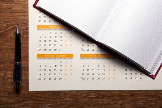 wall calendar with pen and diary closeup photo