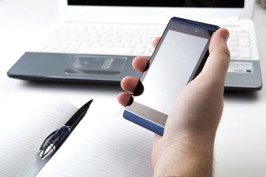human fingers near the notebook keyboard and smartphone photo