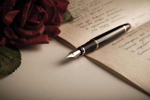 fountain pen on text sheet paper with rose photo
