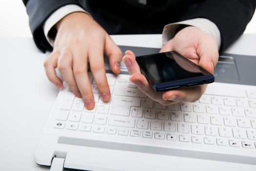 human fingers on the notebook keyboard and smartphone photo